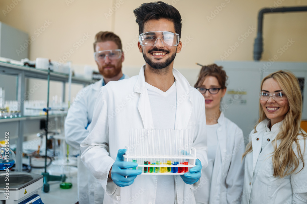 Group of young successful scientists posing for camera Group of young successful scientists posing for camera