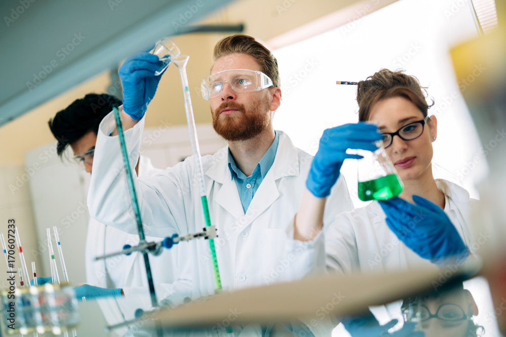 Young students of chemistry working in laboratory Young students of chemistry working in laboratory