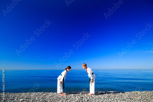 Тренировка двух детей на пляже, на море: тхэквондо, спорт