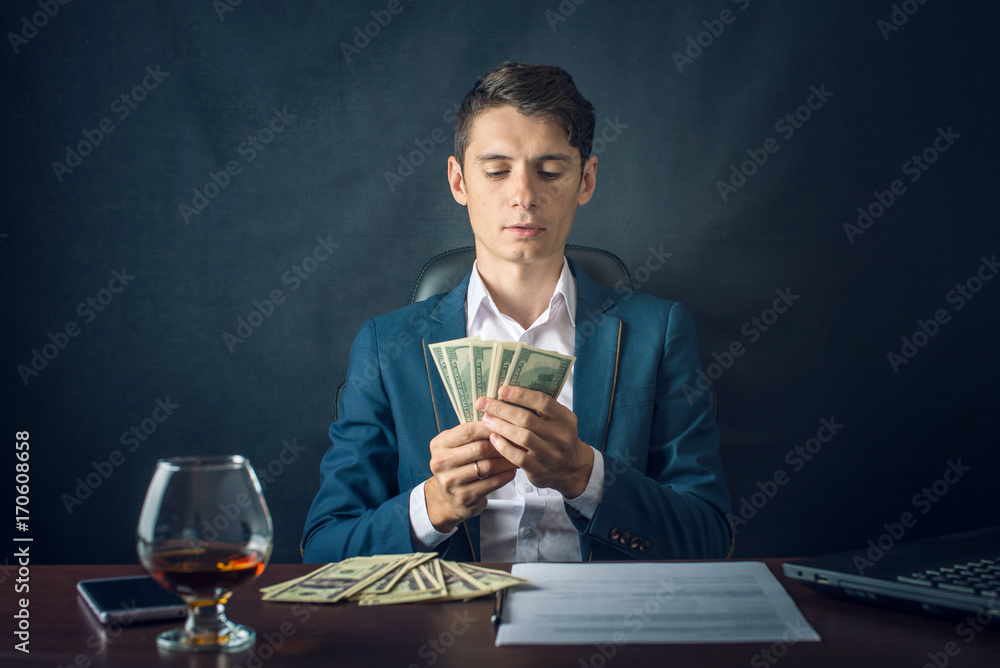 Man Businessman in suit holding money in his hands. Bribe in the form of dollar bills. Concept of corruption and bribery Man Businessman in suit holding money in his hands. Bribe in the form of dollar bills. Concept of corruption and bribery