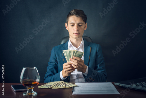 Man Businessman in suit holding money in his hands. Bribe in the form of dollar bills. Concept of corruption and bribery