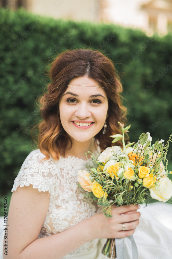 Bride. Beautiful young blond woman in the park with flower wreath and bouquet on a warm summer day Bride. Beautiful young blond woman in the park with flower wreath and bouquet on a warm summer day