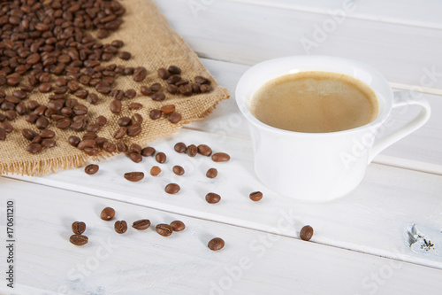 Cup of coffee on a background of coffee beans and a jute bag. 