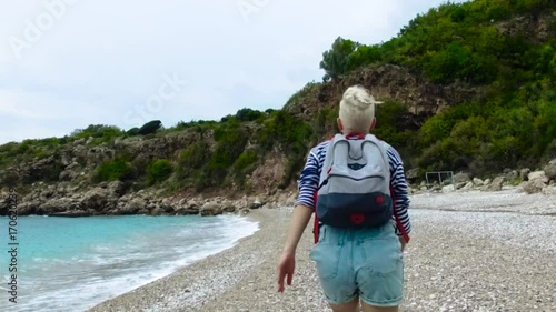 Happy woman walking on the seashore. Footage. Slowmotion photo