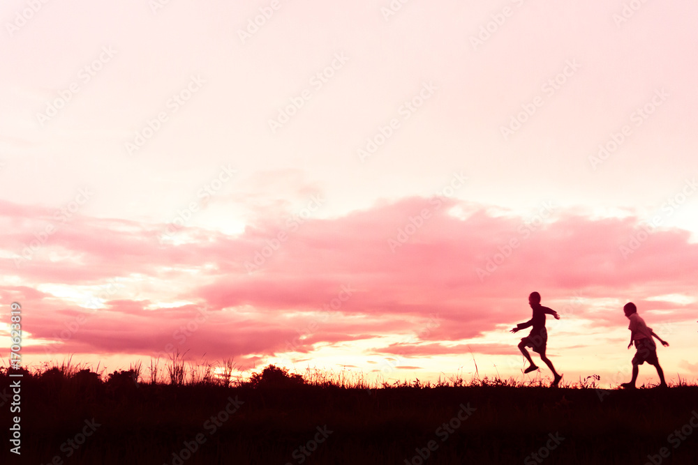 silhouette of a Boy playing on the sunset background