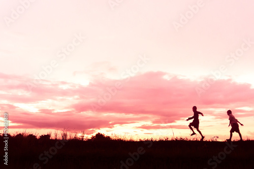 silhouette of a Boy playing on the sunset background