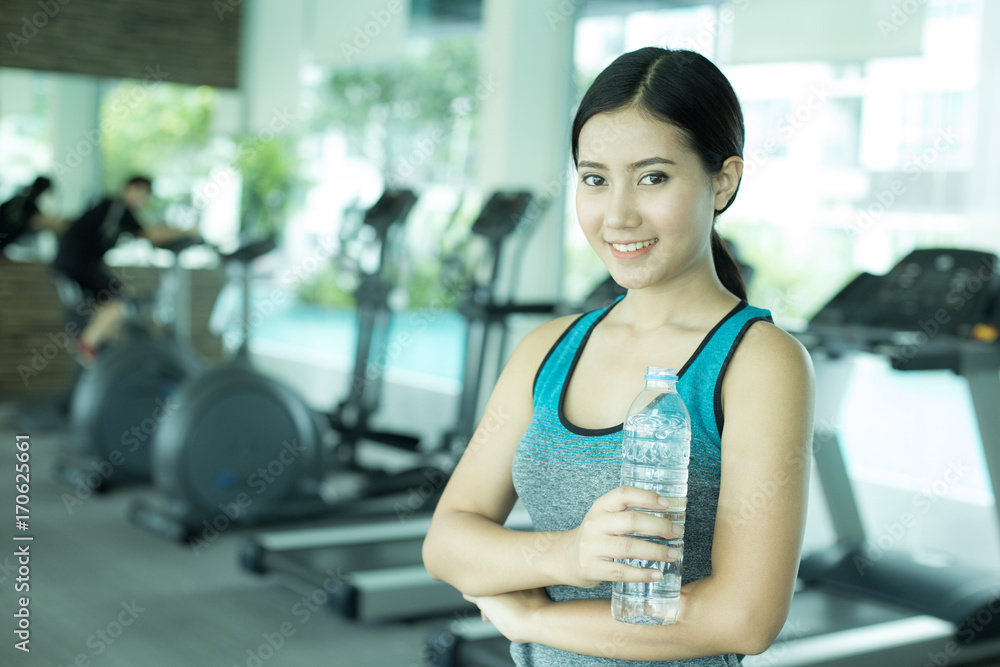 Obraz premium Asian Beautiful Woman holding Water Bottle at Gym, Woman Exercise at Gym Concept.