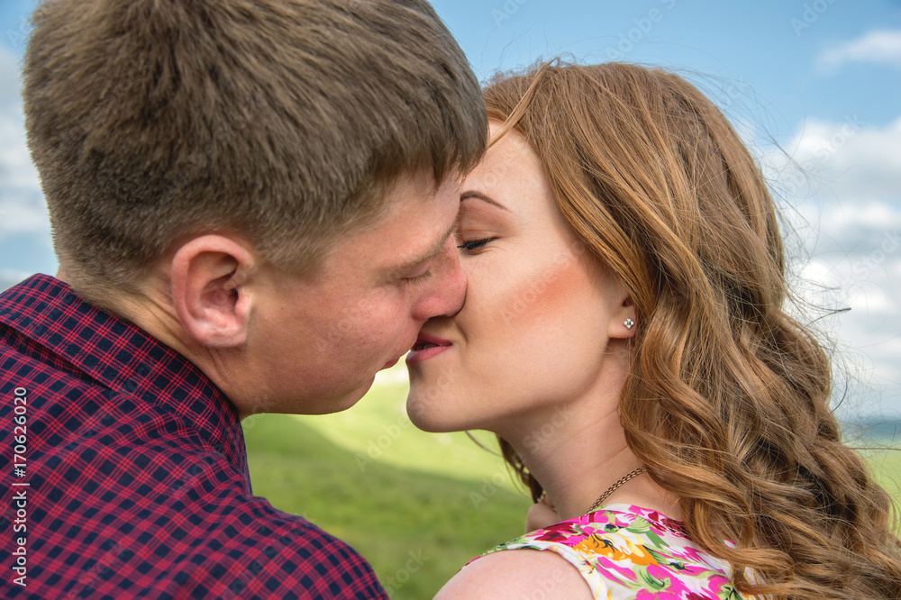 young couple kissing on a background of a landscape close-up young couple kissing on a background of a landscape close-up