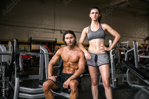 Motivational determined power couple pose during body building fitness weight training session