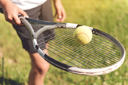 Boy showing ball on racquet © Yakobchuk Olena