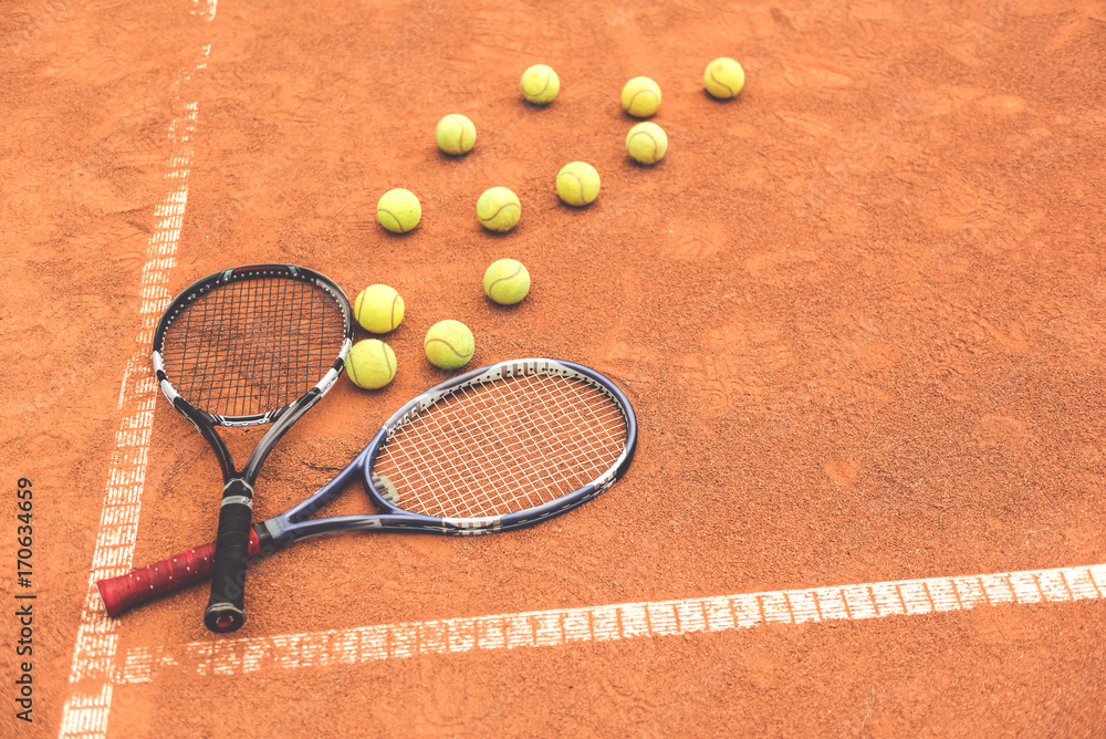 Necessary racquets beside yellow round spheres