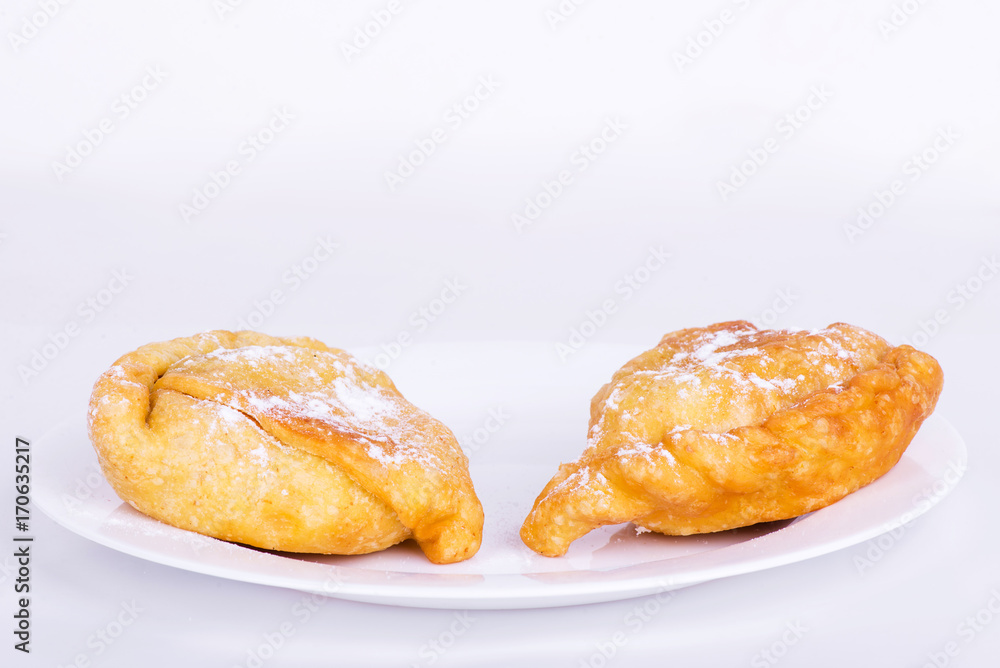 Two sweet samosa on a white plate