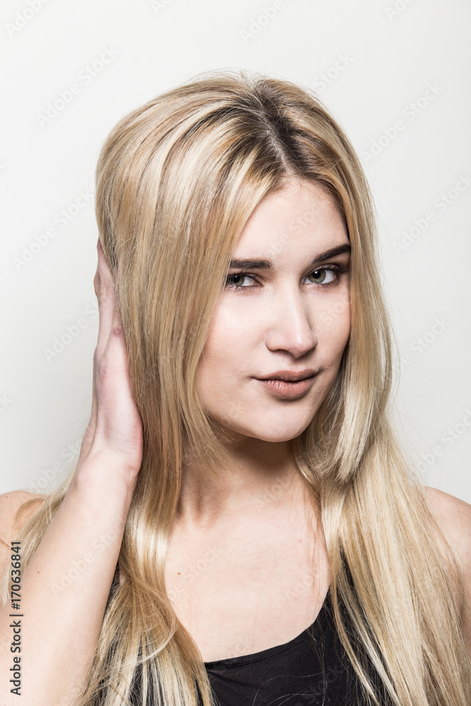 Close-up portrait of a young beautiful blonde girl on a light background. A woman with different emotions on her face. Close-up portrait of a young beautiful blonde girl on a light background. A woman with different emotions on her face.