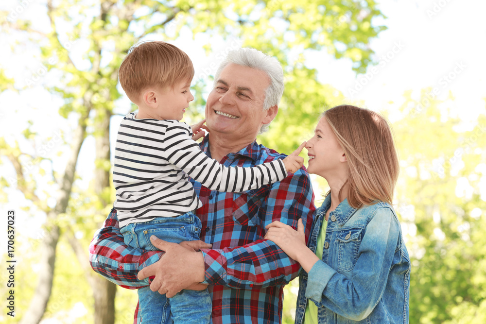 Fototapeta premium Cute happy children with grandfather in spring park