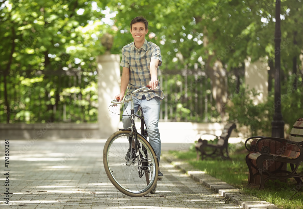 Young handsome man with bicycle outdoors on sunny day Young handsome man with bicycle outdoors on sunny day