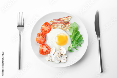 Plate with tasty egg for breakfast on white background