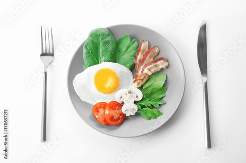 Plate with tasty egg for breakfast on white background