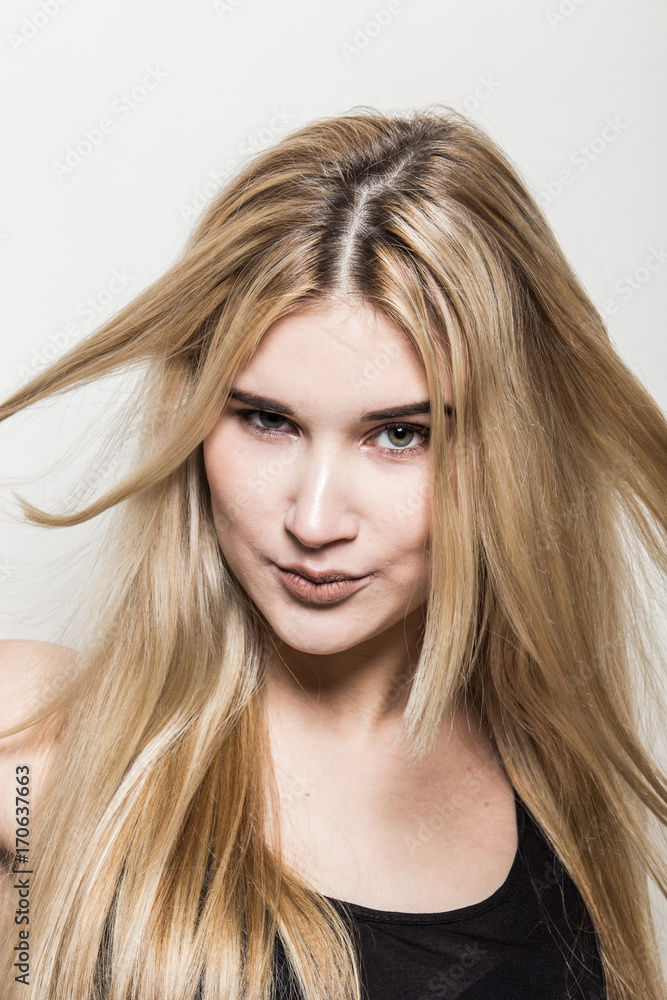 Close-up portrait of a young beautiful blonde girl on a light background. A woman with different emotions on her face. Close-up portrait of a young beautiful blonde girl on a light background. A woman with different emotions on her face.