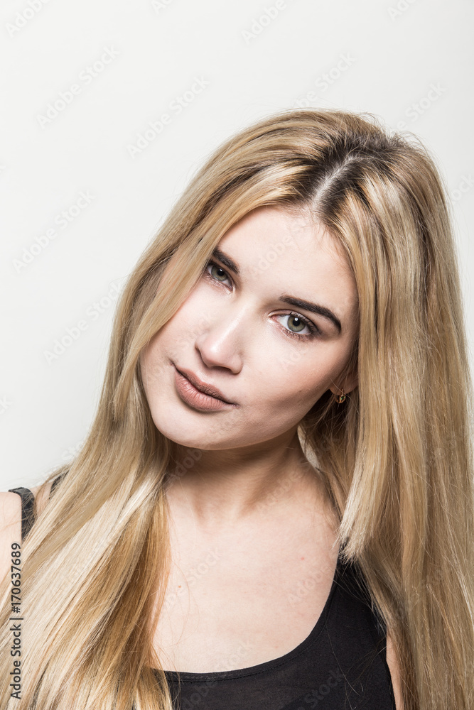 Close-up portrait of a young beautiful blonde girl on a light background. A woman with different emotions on her face. Close-up portrait of a young beautiful blonde girl on a light background. A woman with different emotions on her face.