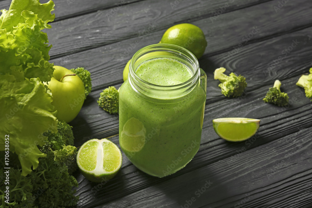 Mason jar with fresh green smoothie on wooden table Mason jar with fresh green smoothie on wooden table