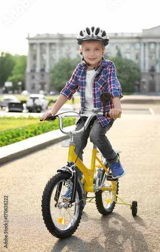 Fototapeta Naklejka Na Ścianę i Meble -  Happy little boy riding bicycle outdoors