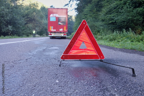 Canvas-taulu Red warning triangle on a road with a broken down truck.