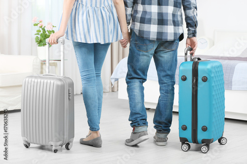 Young couple with luggage in hotel room