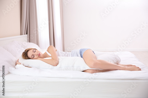Beautiful girl sleeping with body pillow in bedroom