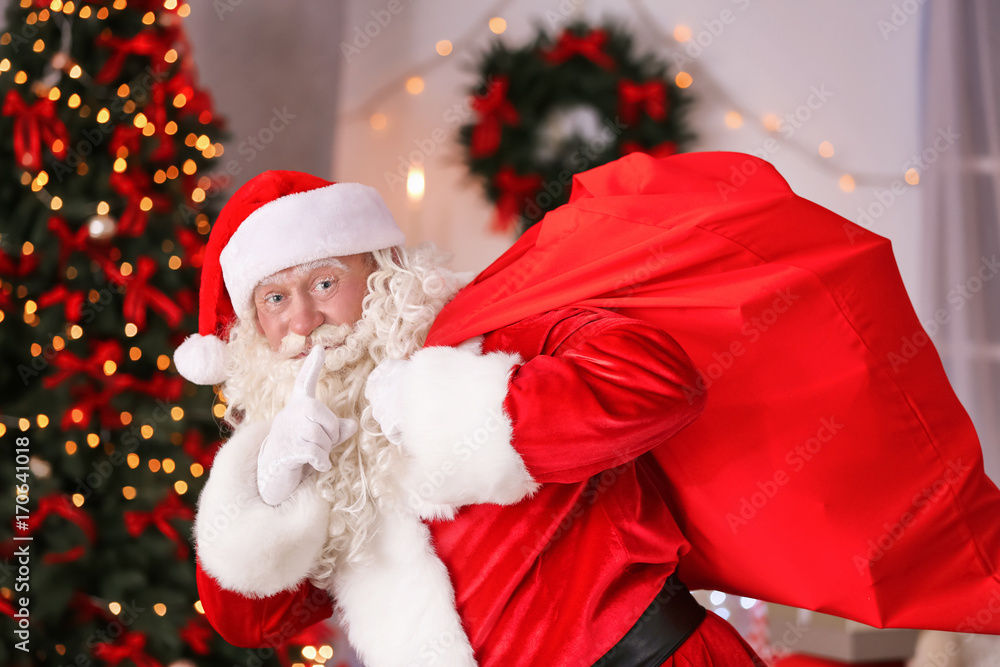 Authentic Santa Claus with big red bag full of gifts against blurred Christmas lights Authentic Santa Claus with big red bag full of gifts against blurred Christmas lights