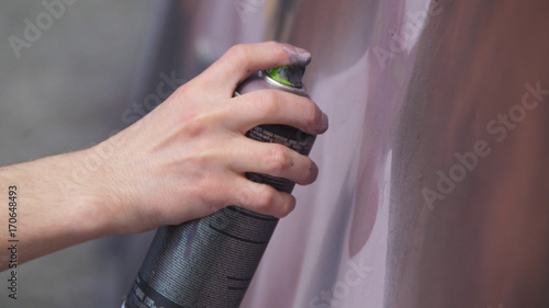 Photography A hand with a spray can that draws a new graffiti on the wall