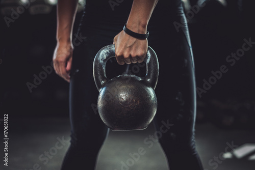 Woman in gym holding a kettlebell. Working Out at Crossfit.