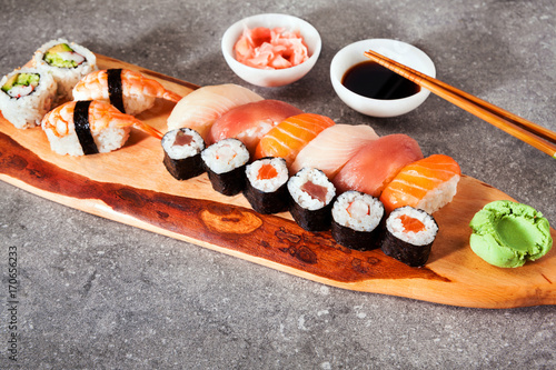 Various kinds of sushi served on a platter with soy sauce, wasab