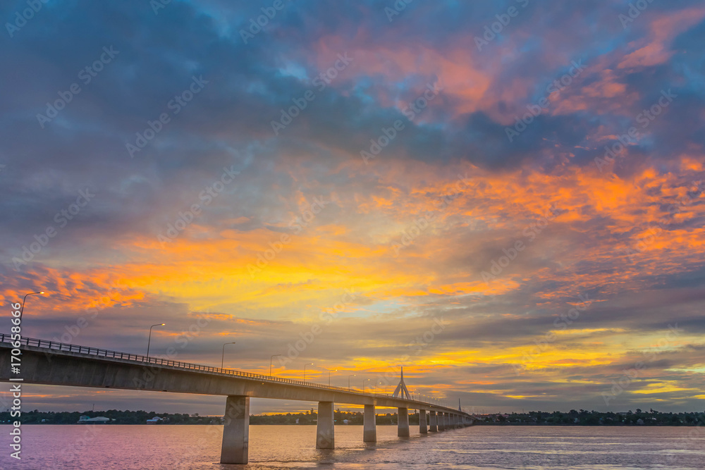 Fototapeta premium Abstract soft blurred and soft focus silhouette sunrise with the beautiful sky in the morning at Thailand, Laos friendship bridge with the beam light and lens flare effect tone.