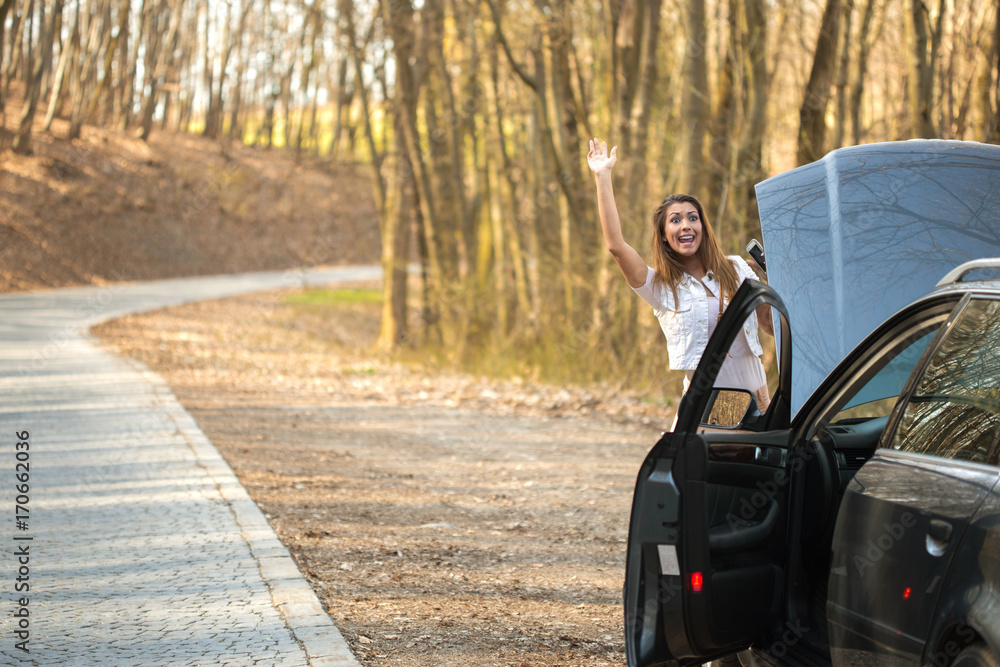 Beautiful young woman waving for help on the road Beautiful young woman waving for help on the road