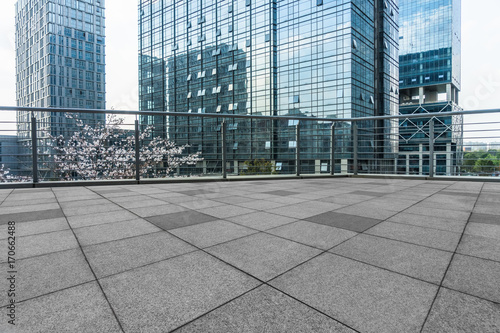 empty pavement and modern buildings in city.