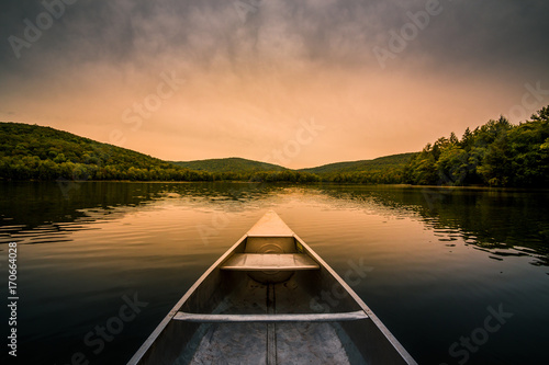 Aluminum canoe on a mountain lake upstate New York. Camping. outdoors and adventure concept.  Faded, vintage color post processed photo