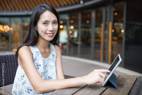 Woman using digital tablet at outdoor coffee shop © leungchopan