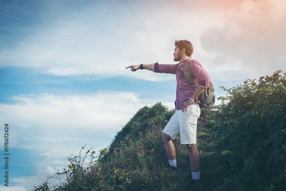 Hiker man with backpack walking up the trail with beautiful mountain peaks view landscape. Hiking in a stormy weather, active lifestyle. Achievement and success. Hiker man with backpack walking up the trail with beautiful mountain peaks view landscape. Hiking in a stormy weather, active lifestyle. Achievement and success.
