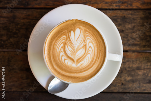 A Cup of hot latte art coffee on wooden table