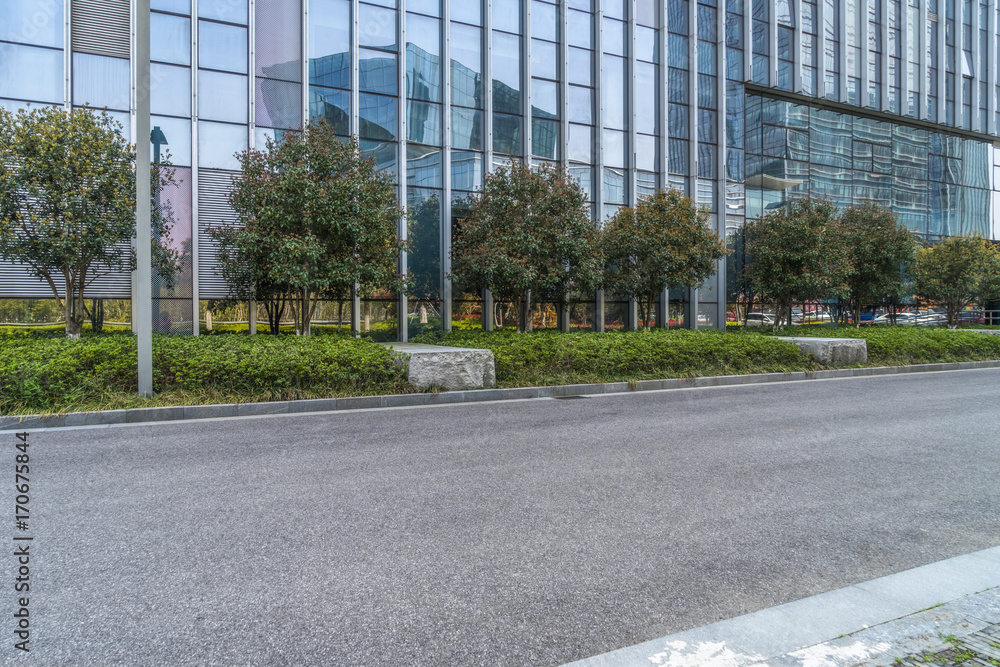 empty asphalt road near glass office building