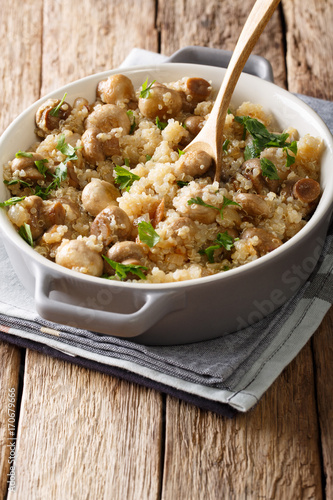 Healthy Food: Quinoa with mushrooms and onions in a pot close-up. vertical