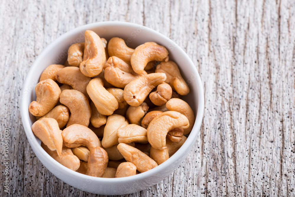 Roasted cashew nuts on rustic wood Roasted cashew nuts on rustic wood
