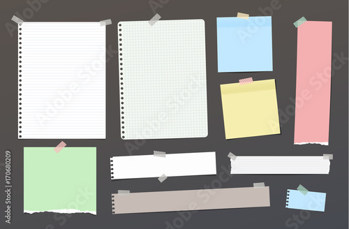 Ripped blank ruled note, notebook, copybook paper strips, sheets stuck with colorful sticky tape on dark background.