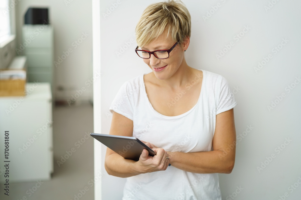 lächelnde mitarbeiterin im büro schaut auf ihr tablet lächelnde mitarbeiterin im büro schaut auf ihr tablet