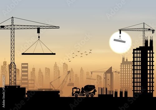 Silhouettes of cranes working on the building