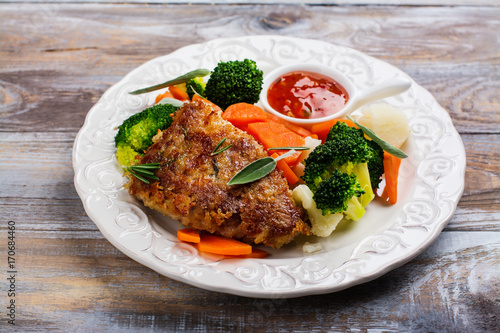 Fried pork steak with vegetables garnish. Copy space