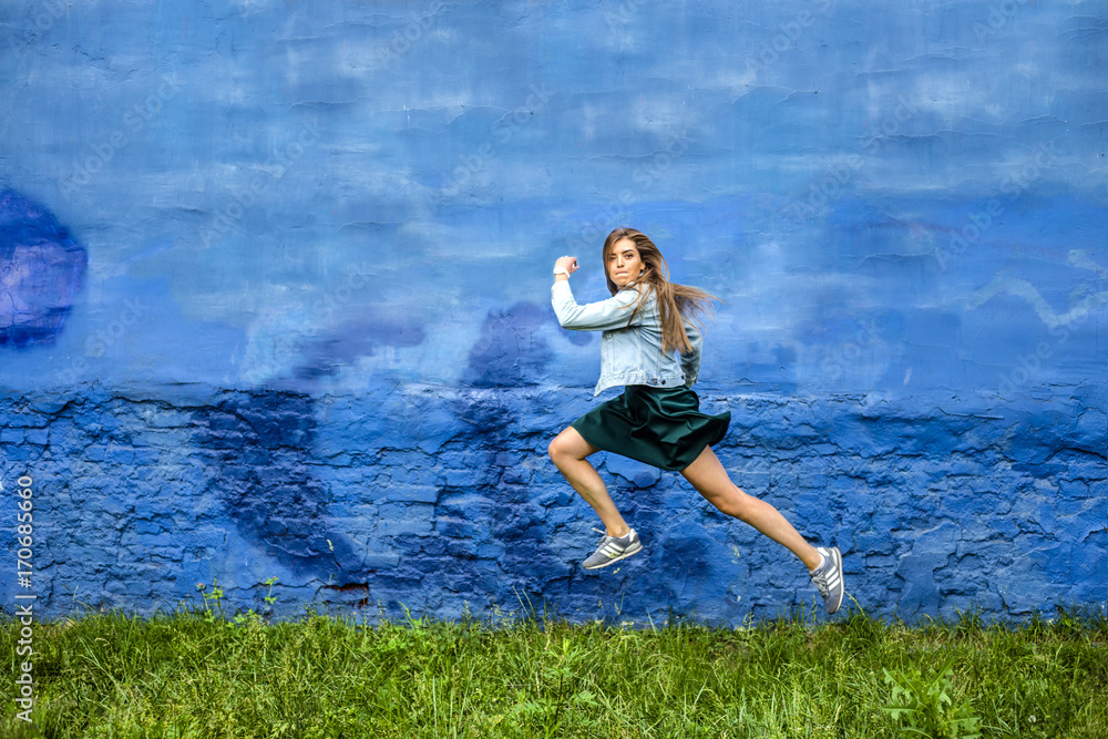 funny jumping young lady on the fairy tale background with crimped face flying and jumping  above the ground. Active, positive, strange, .