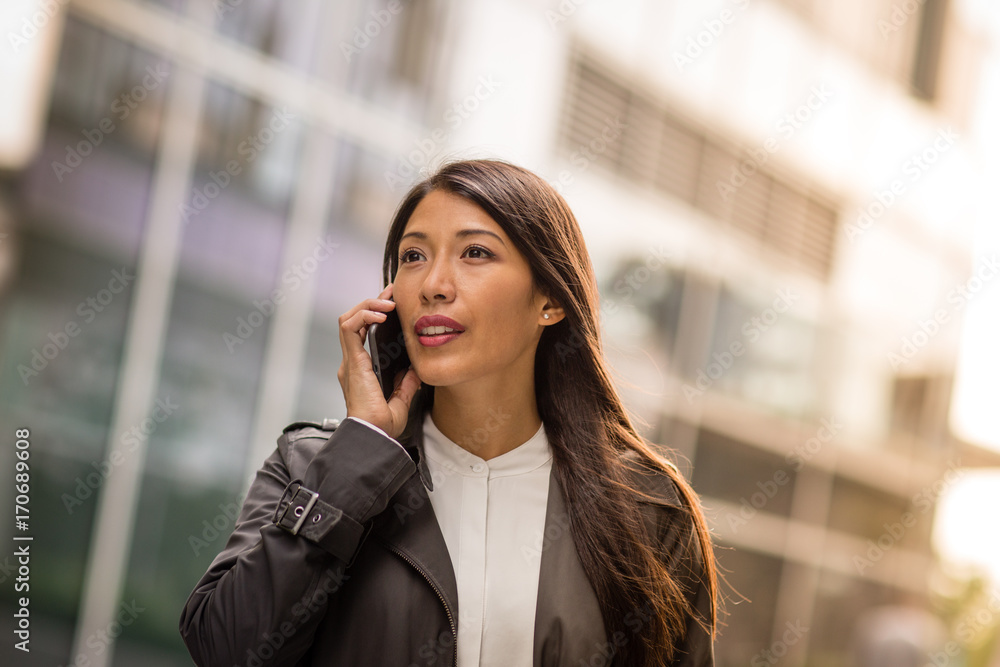 Woman using smartphone walking in city Woman using smartphone walking in city