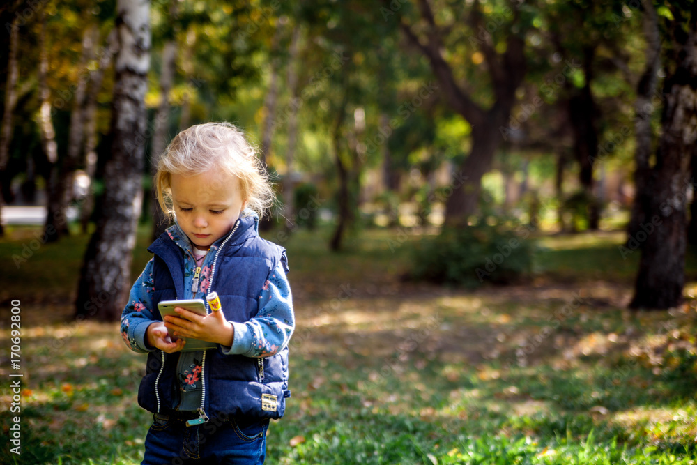 little girl using smartphone for take a photo in the park little girl using smartphone for take a photo in the park