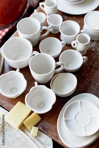 The workplace of ceramist. Baked dishes, ready for painting. A window table